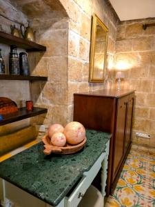 a kitchen with a counter with a bowl of vegetables on it at The Valletta G-House in Valletta +30 photos