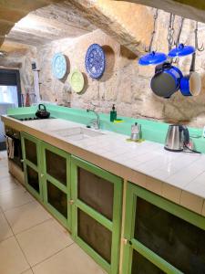 a kitchen with green cabinets and blue plates on the wall at The Valletta G-House in Valletta