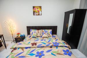 a bedroom with a bed with a floral comforter at Master bedroom apartment in Abu Dhabi +3 photos