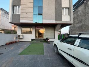 ジャイプールにあるHotel Karma Inn I Hotel Near To Jaipur Airportの建物の前に駐車された白い車