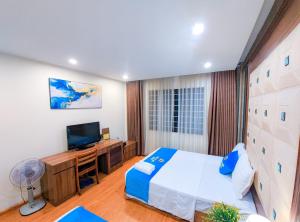 a bedroom with a large bed and a television at Khách sạn Thế Kỷ Mới in Hanoi