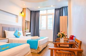 a hotel room with two beds and a table at Khách sạn Thế Kỷ Mới in Hanoi +104 photos