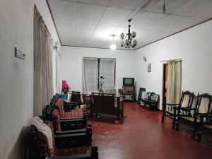 a living room filled with lots of chairs and tables at Esmin's Homestay - Women Only in Hatton