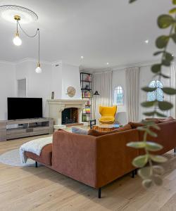 ein Wohnzimmer mit Sofa und Fernseher in der Unterkunft Grande maison chaleureuse à Bouliac in Bouliac