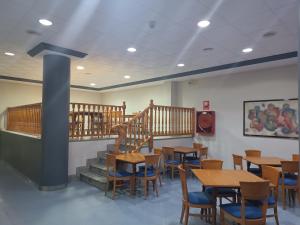 ein Restaurant mit Holztischen und -stühlen und Treppen in der Unterkunft Hotel Rosi in Benicarló