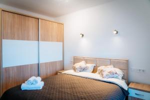 a bedroom with a bed with two towels on it at Apartament spațios cu magazin si bus in Baciu