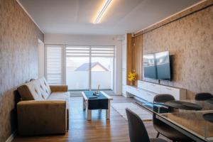 a living room with a couch and a tv at Apartament spațios cu magazin si bus in Baciu