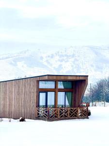 a building in the snow with a mountain in the background at Eco-hotel AQBULAQ in Kaynazarka