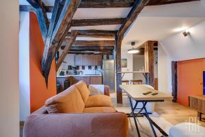 ein Wohnzimmer und eine Küche mit einer Couch und einem Tisch in der Unterkunft Appartement avec 2 chambres, bureau et wifi fibre in Tours