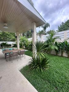 Un patio con una mesa y sillas en un patio. en Casa Tropical Luxe, en Ko Pha Ngan