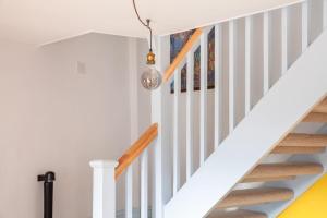 eine Treppe mit weißen Wänden und einer Leuchtvorrichtung in der Unterkunft Cosy Cottage nr The Cotswolds Private Parking in Charfield