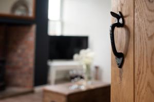 een afsluiting van een houten deur met een handvat bij Hexham Cottage by Coast & Country Stays in Seahouses