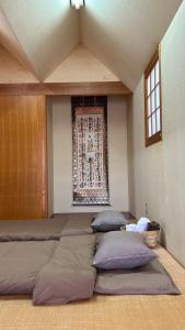 a room with four pillows and a rug on the wall at KUMANO家-CoCo- in Shingu