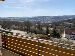 an orange train traveling down the tracks in a town at Apartment Panoramablick in Bad Mergentheim +4 photos