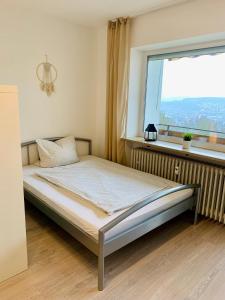 a bed in a room with a large window at Apartment Panoramablick in Bad Mergentheim