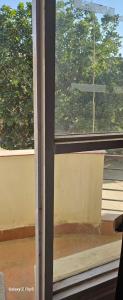 an open window with a view of a tree at Radha Krishna Sharnam in Chhatikara