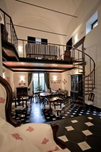 a living room with a staircase and tables and chairs at La Madonetta - Dimora d'epoca - in Levanto