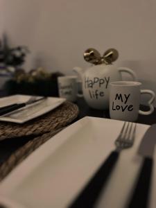 a table with a plate and a fork and a coffee cup at Mokoš apartman, Residence hill A35, minimum dve noći in Kopaonik