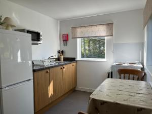 a kitchen with a white refrigerator and a table at Crossgates, Rosehearty in Rosehearty
