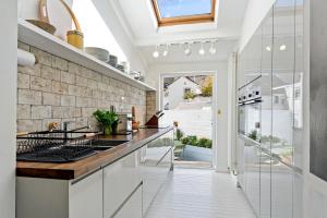a kitchen with white cabinets and a counter top at Waterside cottage - log burner - 10 mins to Falmouth in Flushing