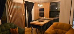 a living room with a table and a kitchen at Bella Lux Centar in Mladenovac