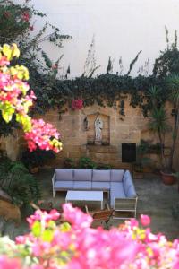 a living room with a couch and some flowers at Charming Xagħra Farmhouse with Pool, Garden & Spacious, Gozo by 360 Estates in Xagħra