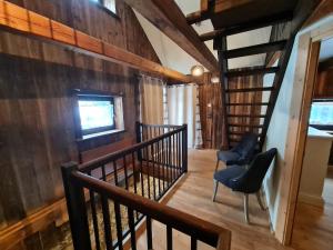 a staircase in a house with two chairs and a window at Die Alte Scheune by Globalimmoservice in Bad Kleinkirchheim