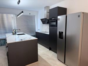 a kitchen with a stainless steel refrigerator and a sink at Moderne woning Drachten 2 slaapkamers dichtbij centrum parking voor de deur in Drachten +29 photos