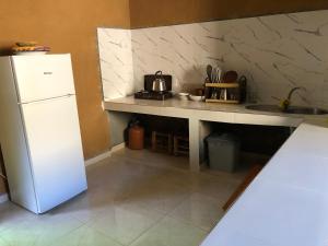 a kitchen with a white refrigerator and a sink at Guest House Tigminou in Setti Fatma +13 photos