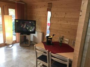 a living room with a tv and a table with a tableablish at Ferienhaus Blockhaus by Seeblick Ferien Edersee in Waldeck