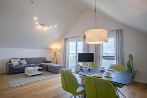 a living room with a table and a couch at Fewo Reeder's Topp by Seeblick Ferien ORO, Penthouse,Panoramablick,Sauna in Olpenitz