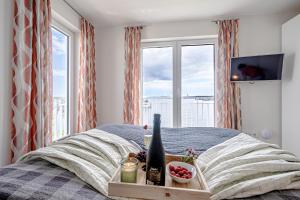 ein Schlafzimmer mit einem Bett mit einem Tablett mit Weinflaschen in der Unterkunft Schleivilla Lootsen Hus by Seeblick Ferien ORO, 3Etagen,8Pers,Sauna,Kamin in Olpenitz