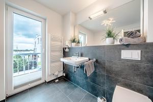 ein Badezimmer mit Waschbecken und Spiegel in der Unterkunft Schleivilla Lootsen Hus by Seeblick Ferien ORO, 3Etagen,8Pers,Sauna,Kamin in Olpenitz + 32 Fotos