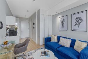 a living room with a blue couch and a table at Bhonsane Executive Suite, Ellipse, Midrand in Midrand