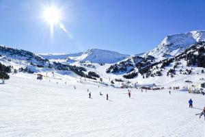 a group of people skiing down a snow covered slope at Apartamentos Solaris 3000 in Pas de la Casa