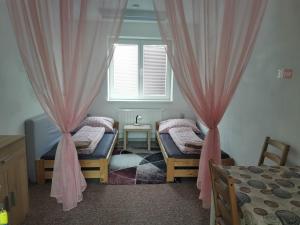 a bedroom with two beds and a window with curtains at LIVING BRATISLAVA by the BUS STATION in Bratislava