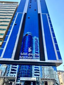 a tall blue building with a sign on it at فندق رفاق العالية in Makkah