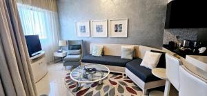 a living room with a couch and a tv at Superb 1 BR apt next to Burj Khalifa and Dubai mall in Dubai