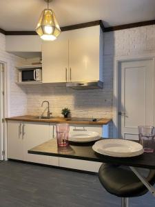 サンルーカル・デ・バラメダにあるApartamento Plaza del Cabildo - Sanlúcar Centroのキッチン(テーブル上に白い皿2つ付)