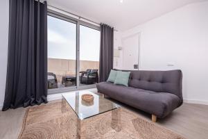 ein Wohnzimmer mit einer Couch und einem Glastisch in der Unterkunft Sweett - Harmony Central in Barcelona