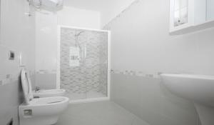 a bathroom with a shower and a toilet and a sink at Gelsomino in Marina di Campo +4 photos