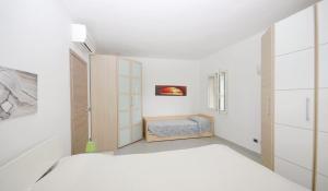 a white bedroom with a bed and a window at Gelsomino in Marina di Campo