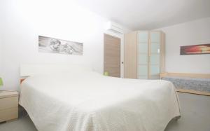 a white bedroom with a large white bed in it at Gelsomino in Marina di Campo