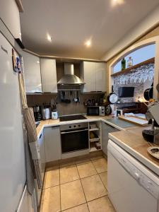 a kitchen with white cabinets and a refrigerator at Casa Barmalei Private Pool & Rooftop Terrace Ocean View, Tenerife in Callao Salvaje +27 photos