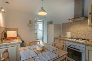a kitchen with a table and a kitchen with a stove and refrigerator at Le Francvillois in Villefranche-Sur-Cher