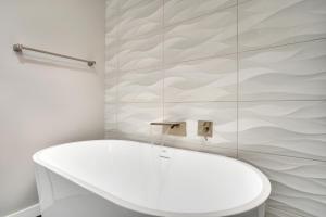 a bathroom with a white tub and a toilet at Main Street Retreat Chatt in Chattanooga +18 photos