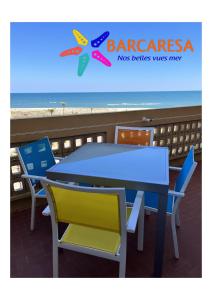une table et des chaises avec la plage en arrière-plan dans l'établissement BARCARESA-Elégant appartement vue mer wifi parking, au Barcarès