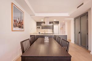 eine Küche und ein Esszimmer mit einem Holztisch und Stühlen in der Unterkunft Sweett - Harmony Central in Barcelona + 8 Fotos