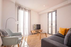 ein Wohnzimmer mit Sofa und Fernseher in der Unterkunft Sweett - Harmony Central in Barcelona
