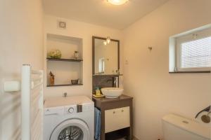 a bathroom with a washing machine and a sink at Le Francvillois in Villefranche-Sur-Cher